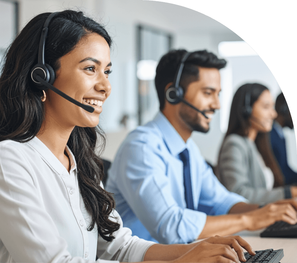 Atendente sorridente com headset trabalhando em sua estação no contact center, representando a alta produtividade e o maior tempo falado garantidos pelo ajuste automático do discador preditivo.