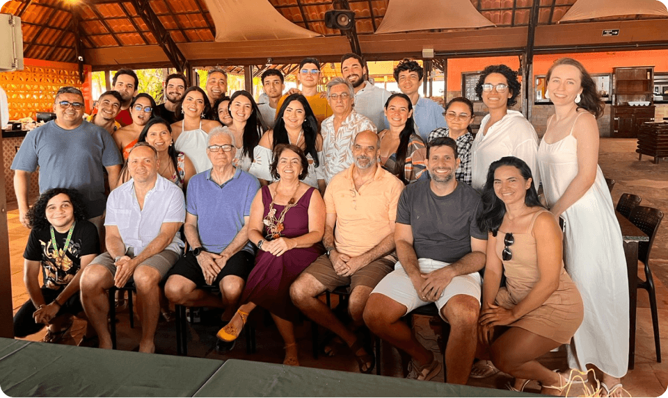 equipe-tactium-tecnologia-empatia-atendimento-humanizado Grande grupo de colaboradores da Tactium posando sorridentes para uma foto em um ambiente descontraído, ilustrando a união de tecnologia e empatia para transformar o atendimento em algo realmente humano.